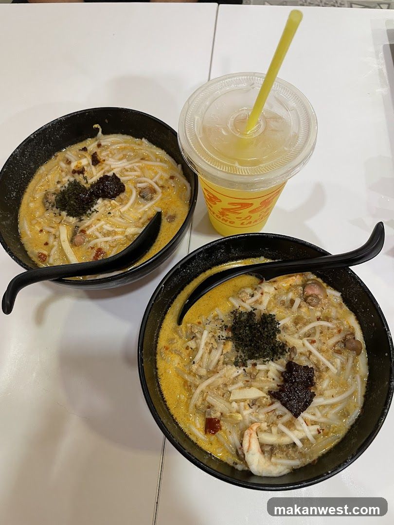 Two bowls of Laksa with a drink