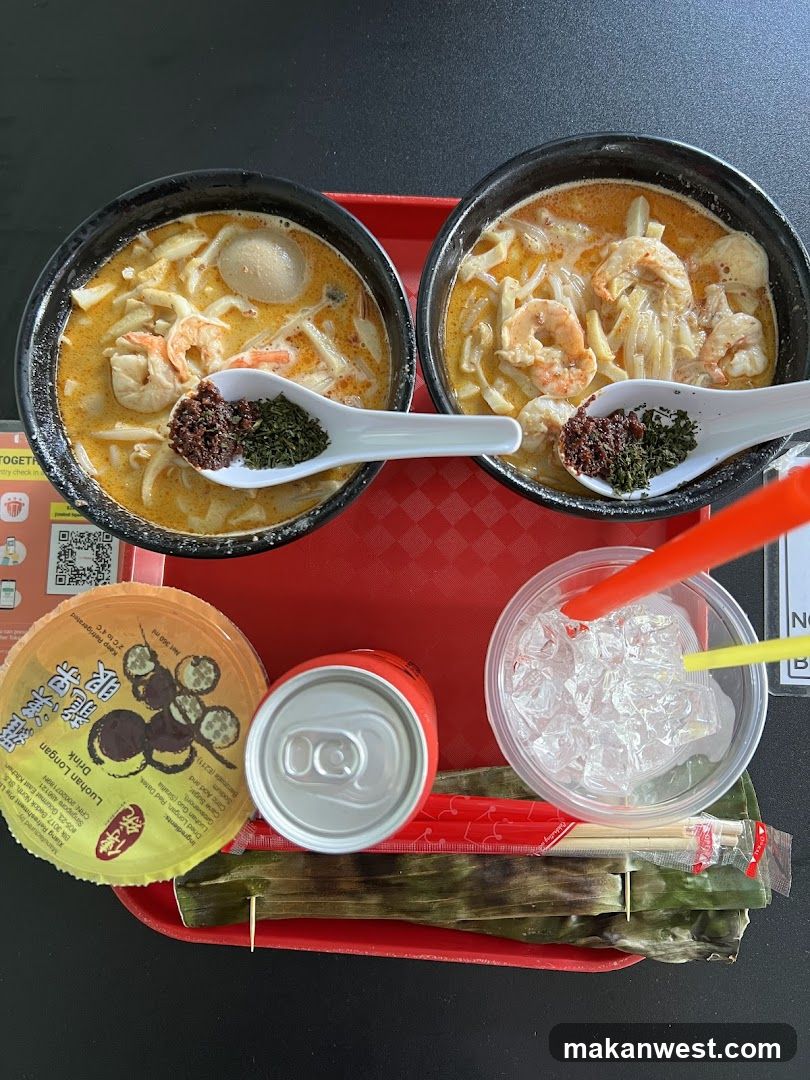 Two bowls of Laksa with toppings and a drink