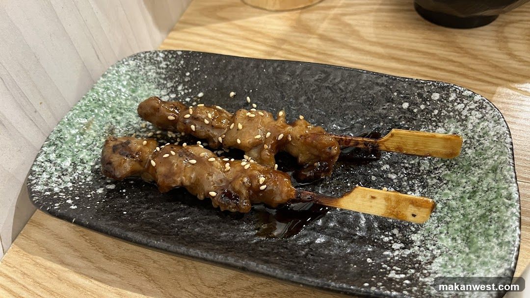 Two skewers of grilled meat with sesame seeds