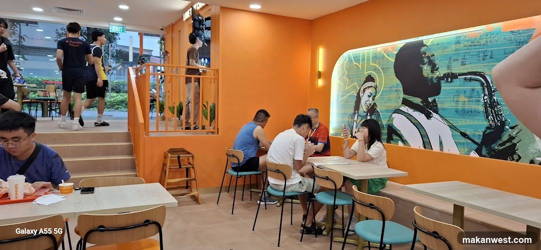 Diners in a brightly lit restaurant with orange walls and jazz-themed murals.