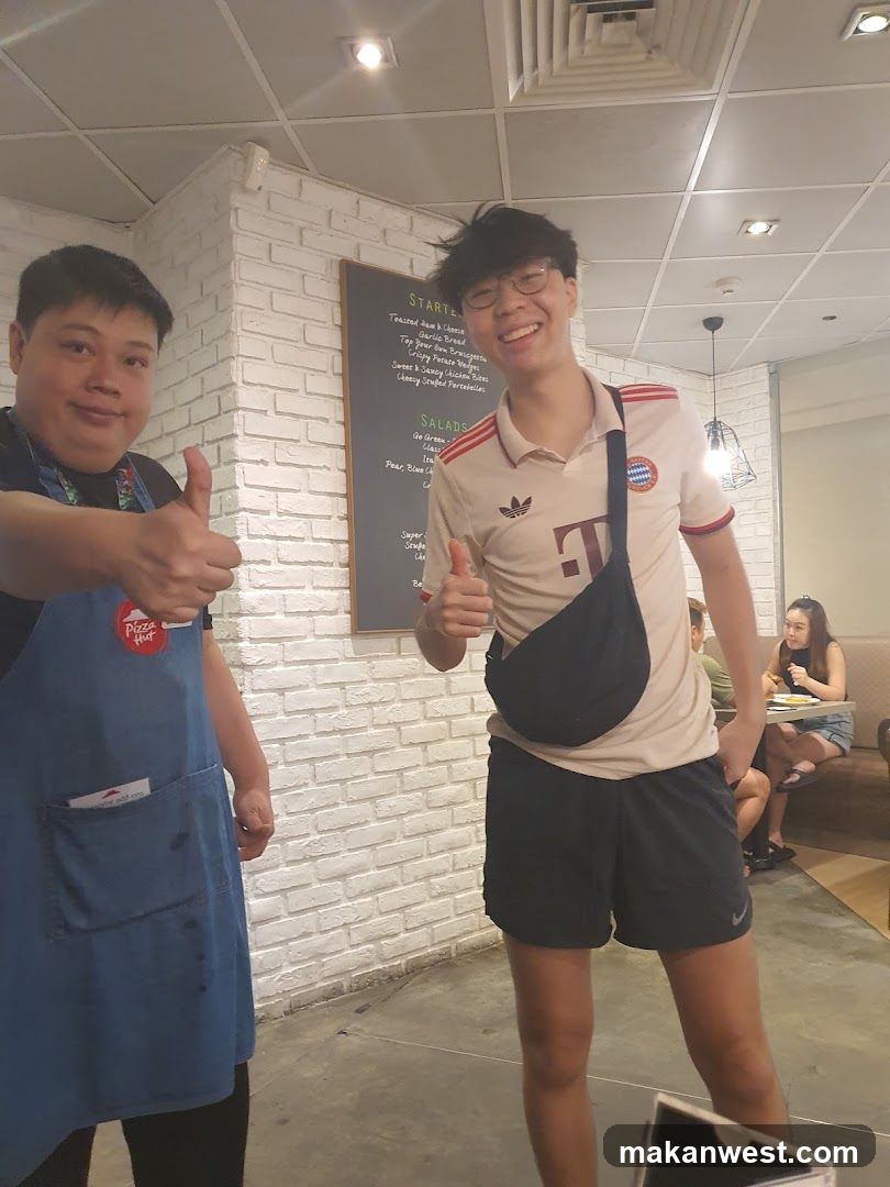 Two people giving thumbs up in a restaurant