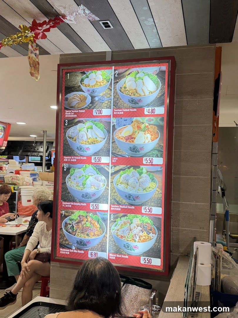 A menu board displaying various noodle dishes with images and prices.