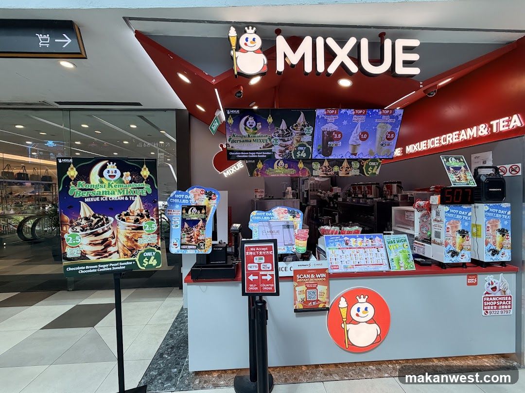 A Mixue Ice Cream & Tea store with a prominent red and white sign. The storefront features a counter with various promotional displays for ice cream and chilled tea. Digital screens show menu items and prices. A large poster on the left advertises a special offer for "Chocolate Brown Sugar Pearl Sundae + Chocolate Cookies Sundae" for $4. The counter area has a digital display showing "507" and promotional posters for "Hot Day Chilled Tea".