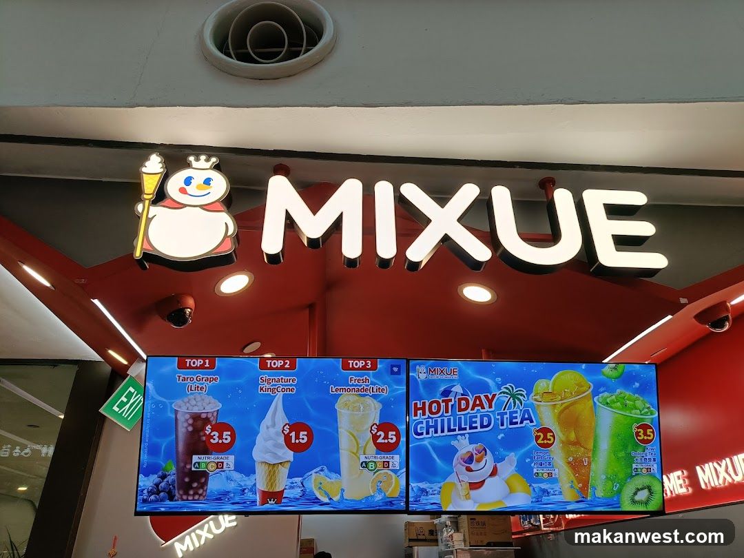 A brightly lit storefront with a large illuminated sign displaying the brand name "MIXUE" and its mascot. Below the sign is a digital menu board showcasing various drinks and ice cream cones with prices. An "EXIT" sign is visible to the left.
