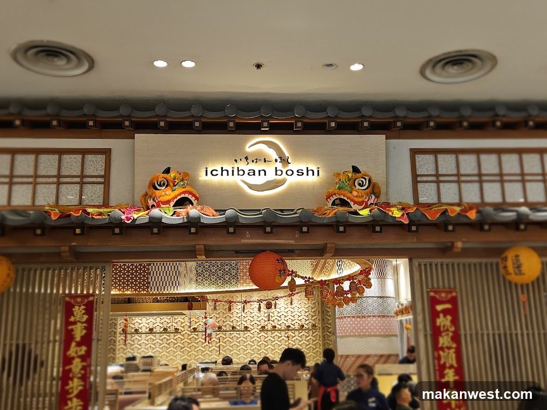 The exterior of the Ichiban Boshi restaurant features a prominent sign with the restaurant's name and logo. The entrance is decorated with traditional Chinese lion heads and festive lanterns, suggesting a celebratory atmosphere. The interior of the restaurant is visible through the entrance, showing diners seated at tables.