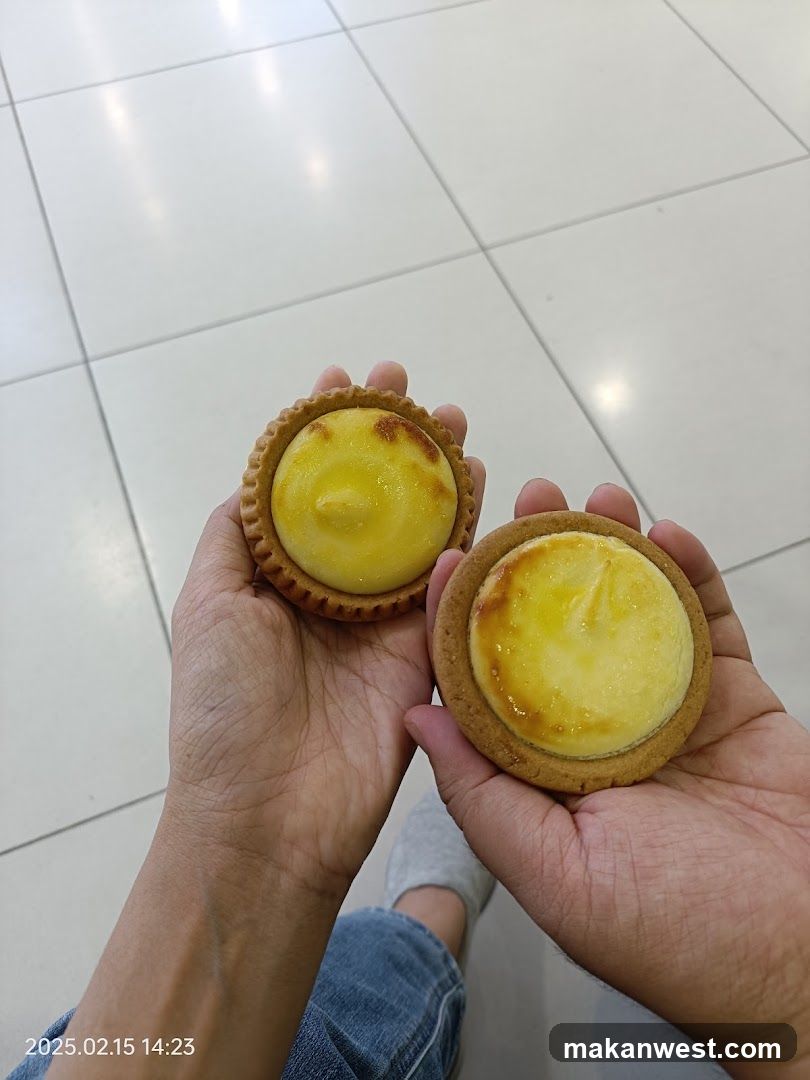 Two Egg Tarts Held in Hands