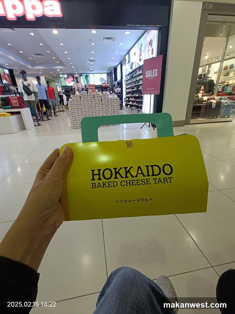 Hand holding Hokkaido Baked Cheese Tart box in shopping mall