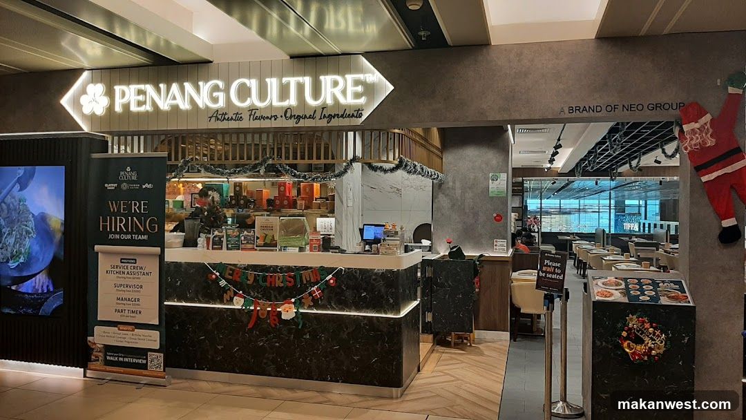 The image shows the storefront of Penang Culture, a restaurant with visible signage and festive decorations including Christmas garlands and banners. A hiring poster is displayed on the left side.