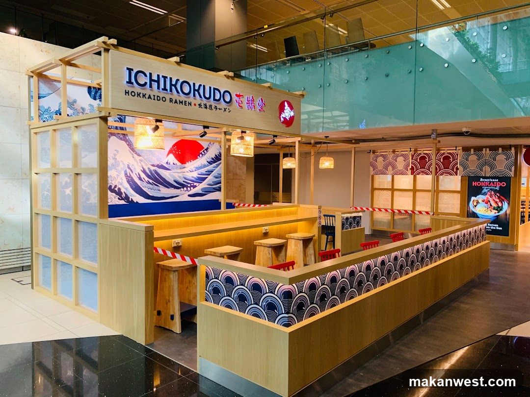 The image shows the exterior of a ramen shop named 'ICHIKOKUDO HOKKAIDO RAMEN' with visible signage on the building facade. The storefront features wooden paneling, decorative wave patterns, and hanging lanterns.