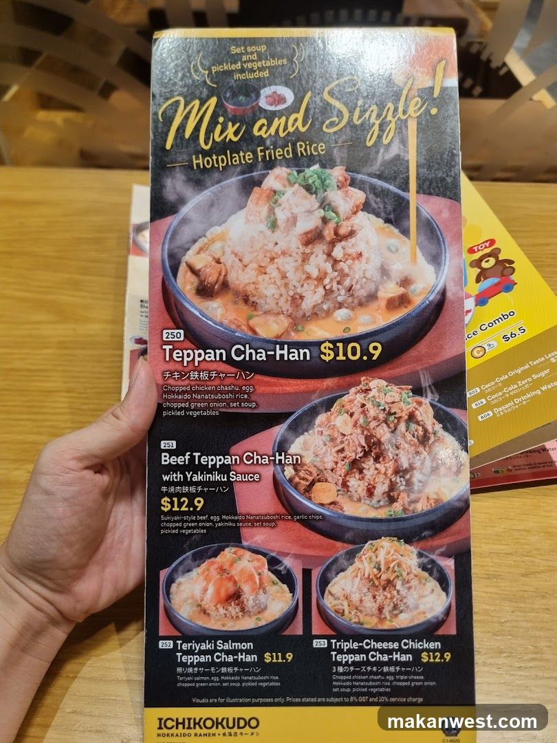 A hand holds a menu page featuring hotplate fried rice dishes, including Teppan Cha-Han and Beef Teppan Cha-Han with Yakimiku Sauce.