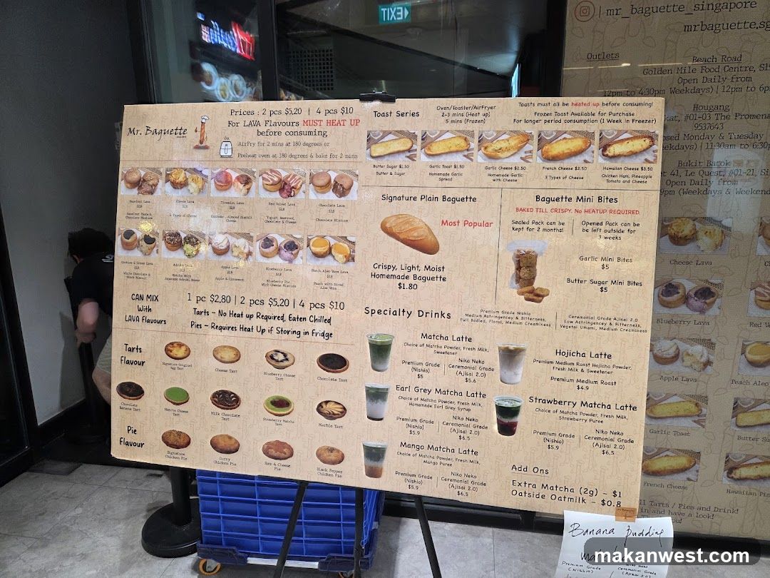 A large printed menu board displaying various baked goods and drinks, including baguettes, tartlets, pies, matcha lattes, and mini bites.