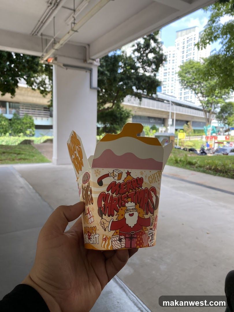 Christmas-themed food container held outdoors