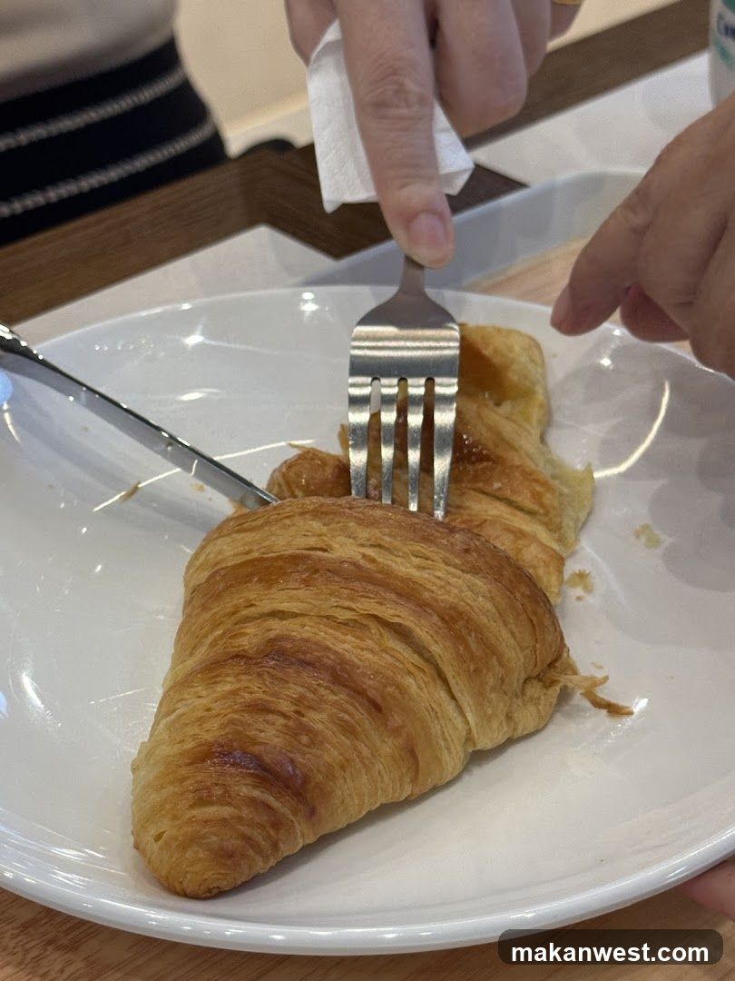 Croissant being cut with fork