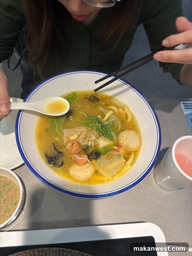 Person eating soup with chopsticks and spoon