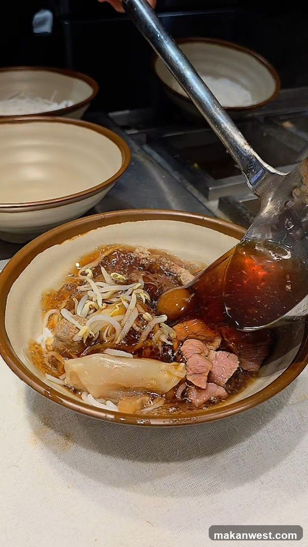Noodle Bowl with Broth Being Poured