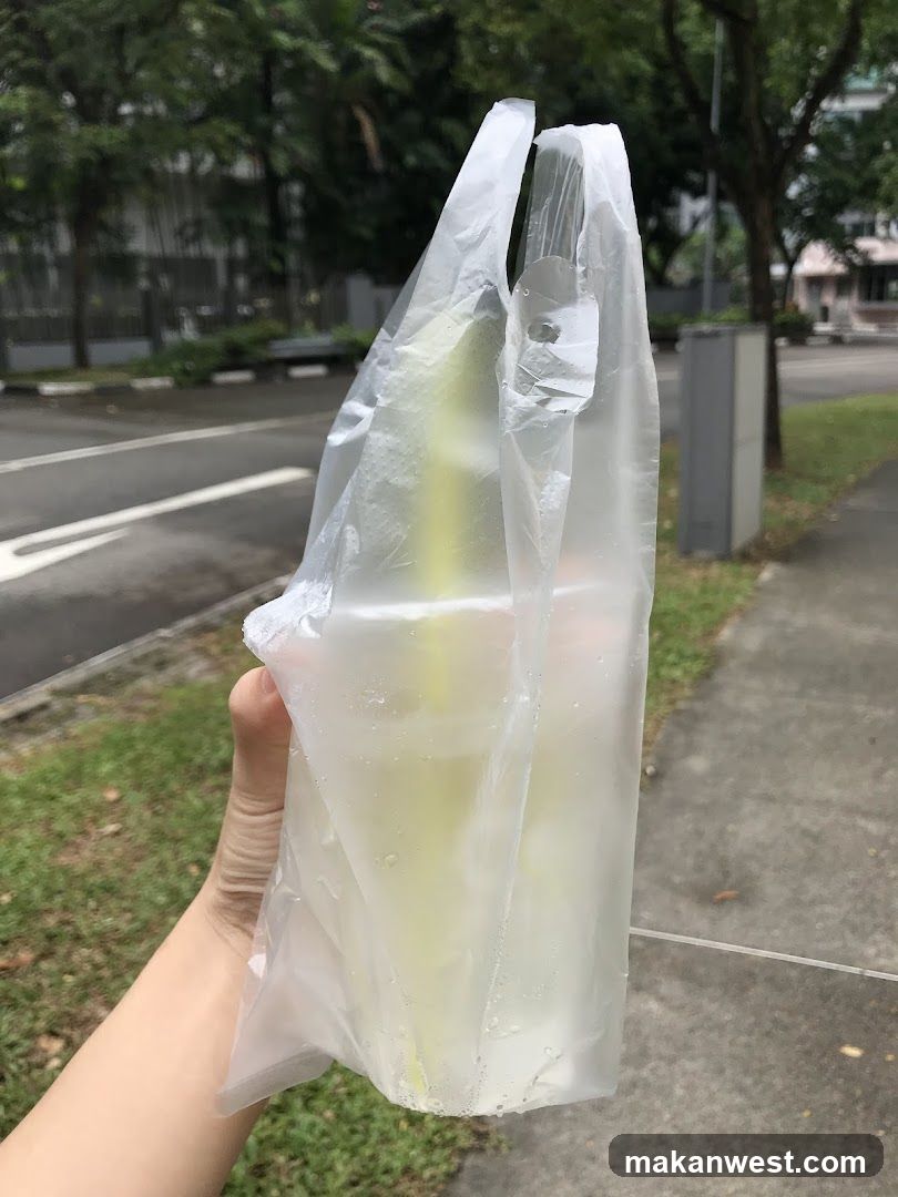 Hand holding a plastic bag with drinks