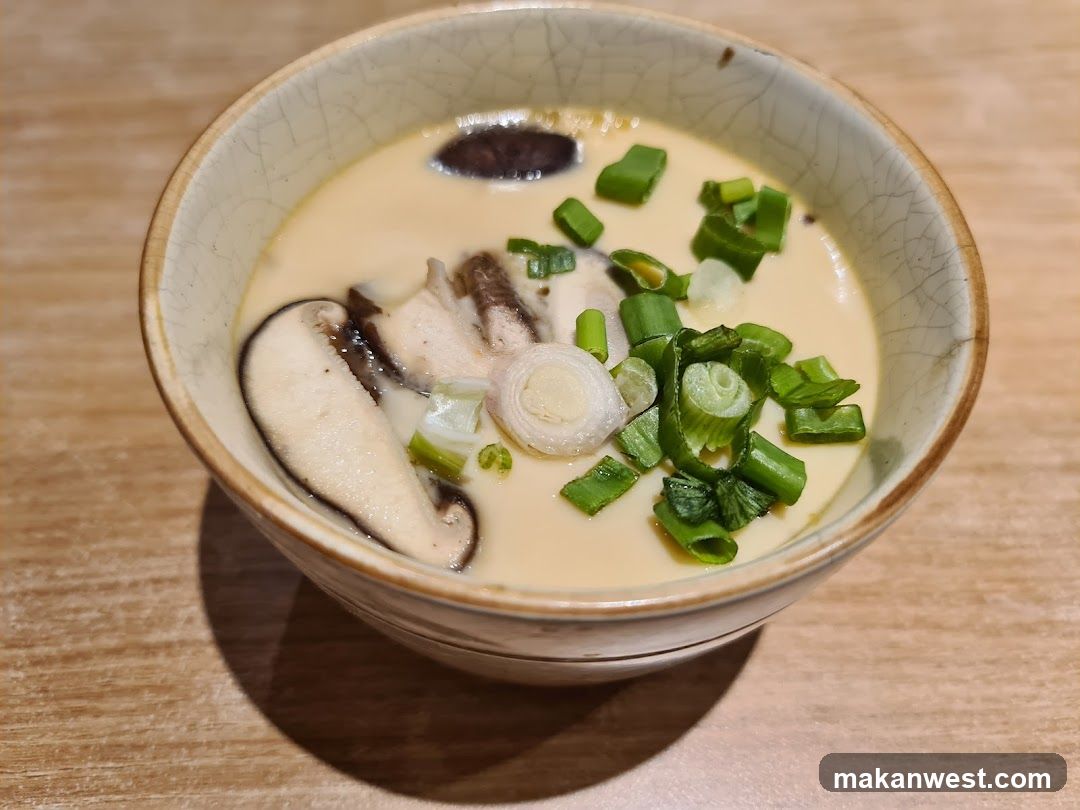 Bowl of creamy soup with mushrooms and green onions