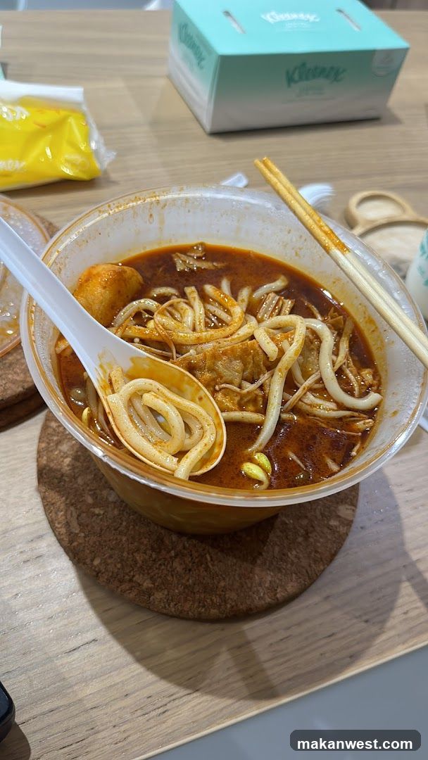 Spicy Noodle Bowl with Chopsticks and Spoon