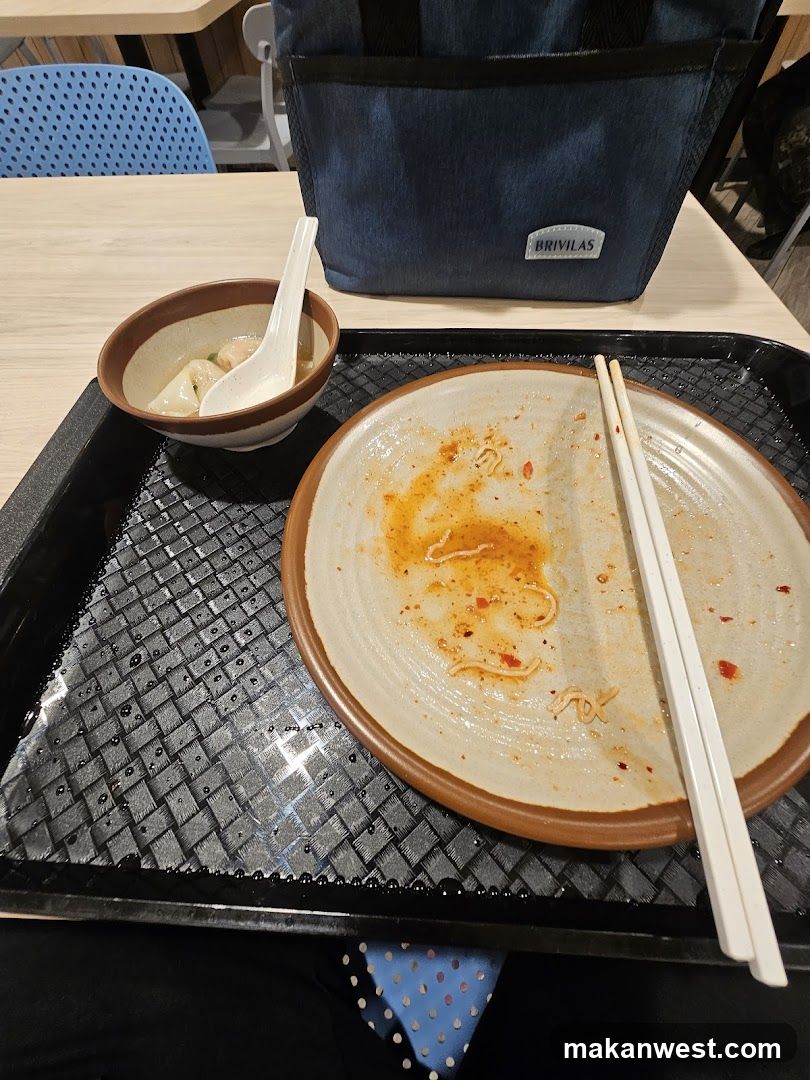 Empty Meal Tray with Leftover Soup and Noodles