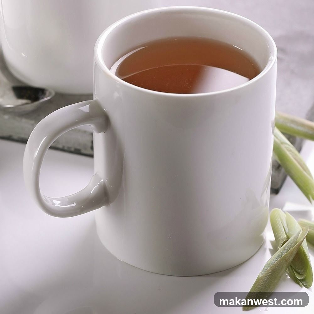 White Mug with Tea and Green Stems