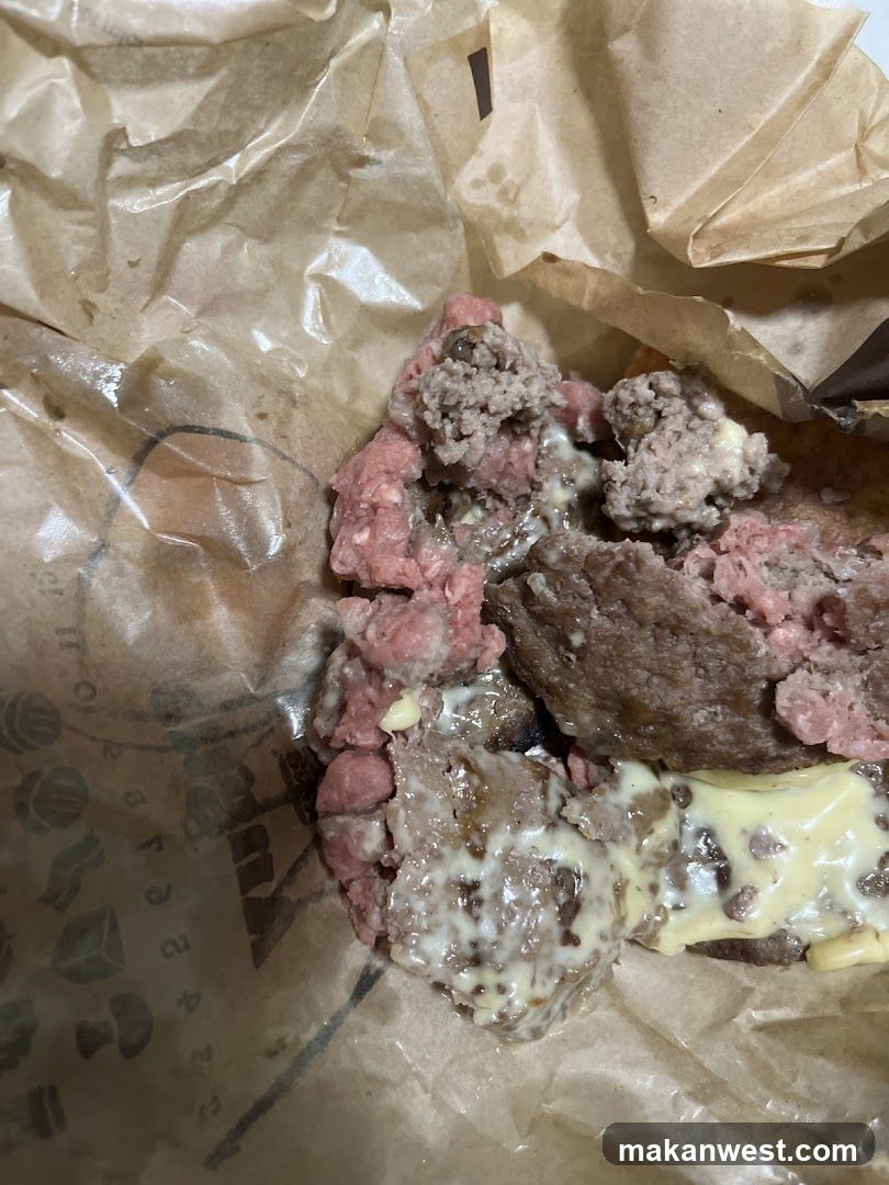 Burger with meat patty and cheese on brown paper wrapper