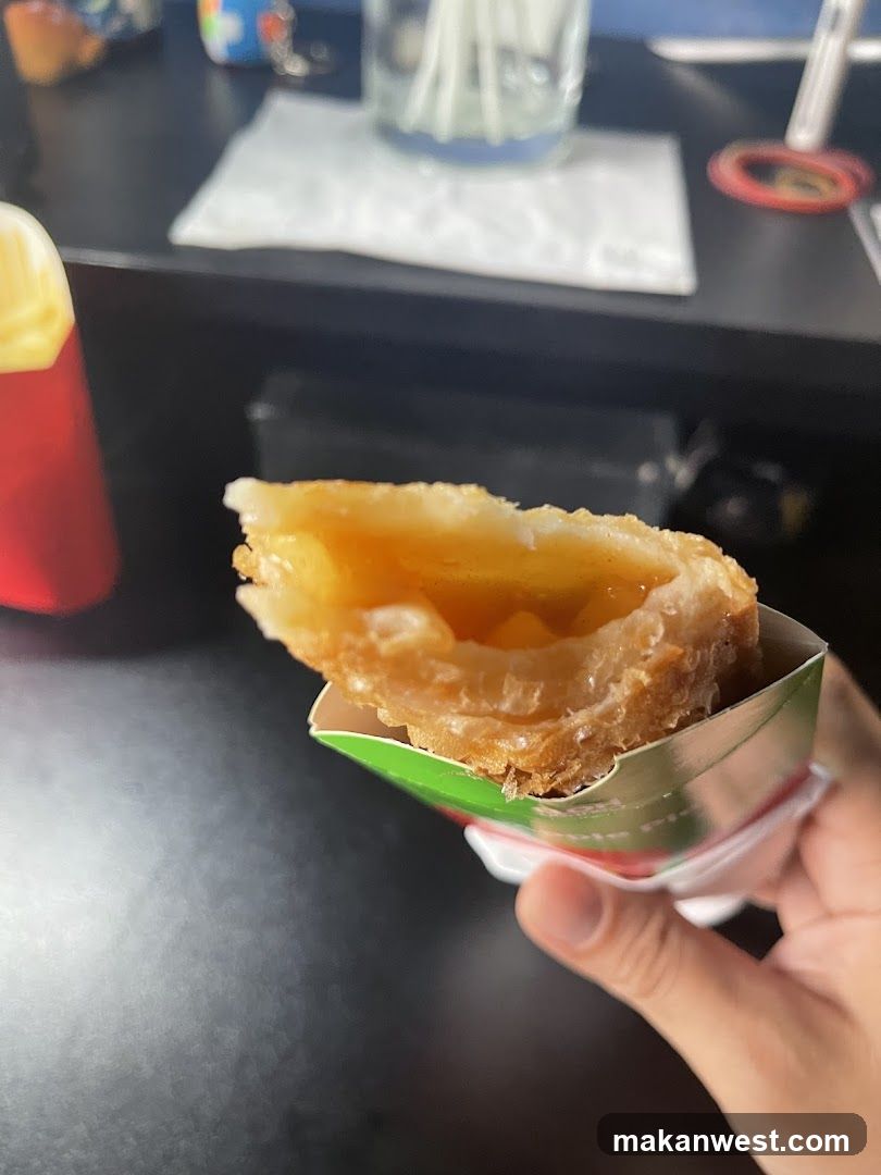 Hand holding a pastry with filling