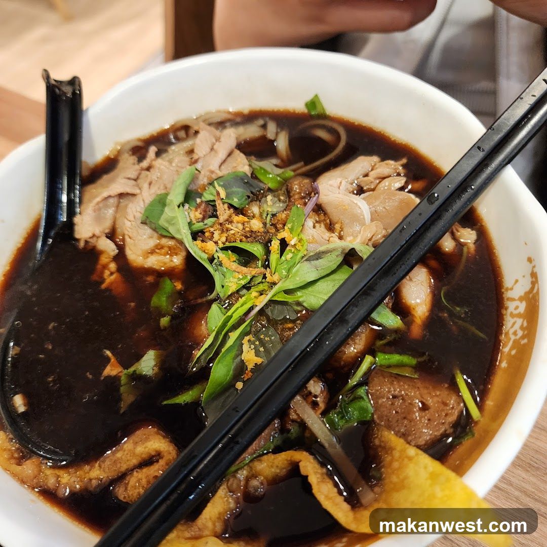 Bowl of Dark Broth Noodle Soup with Toppings