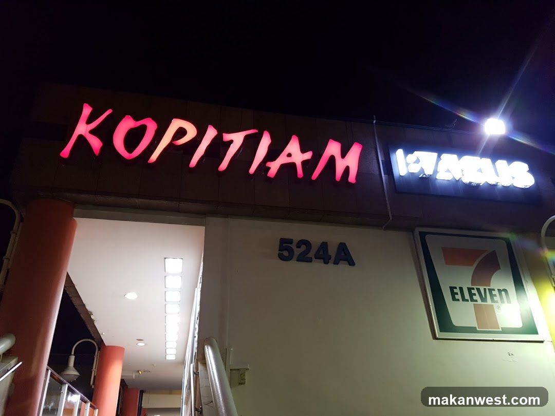 Kopitiam and 7-Eleven storefront at night