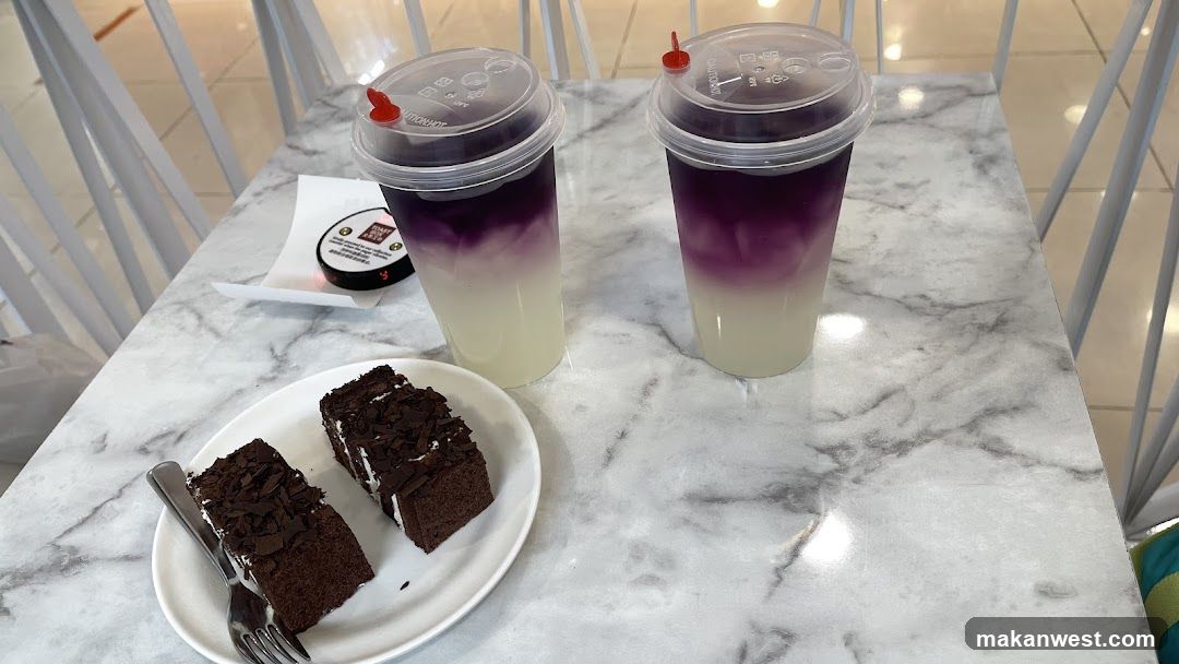 Purple layered drinks and chocolate cake on marble table