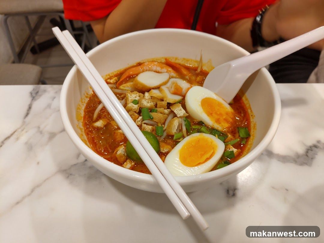 Bowl of Spicy Ramen with Halved Eggs and Tofu