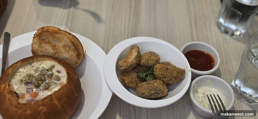 Bowl of soup with bread and fried items