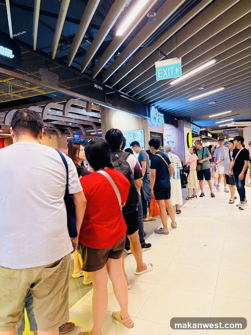Crowded indoor corridor with people waiting in line