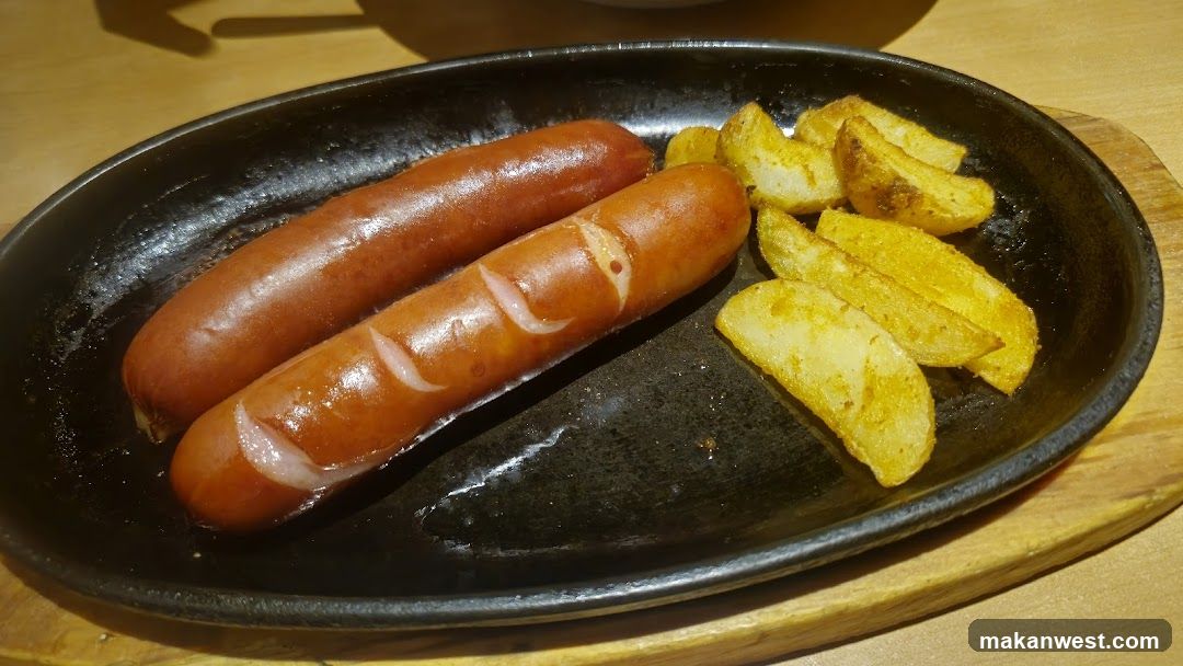 Sausages and Potato Wedges on a Black Plate