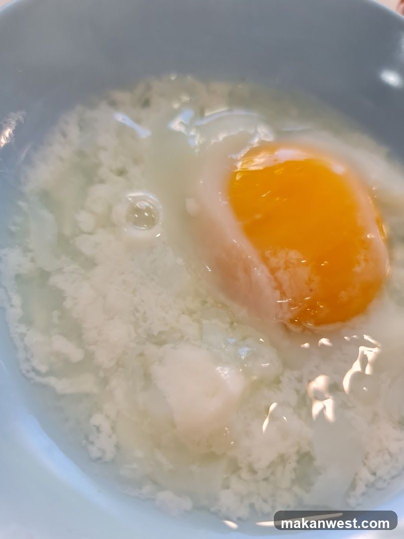 Raw Egg in Bowl with Flour