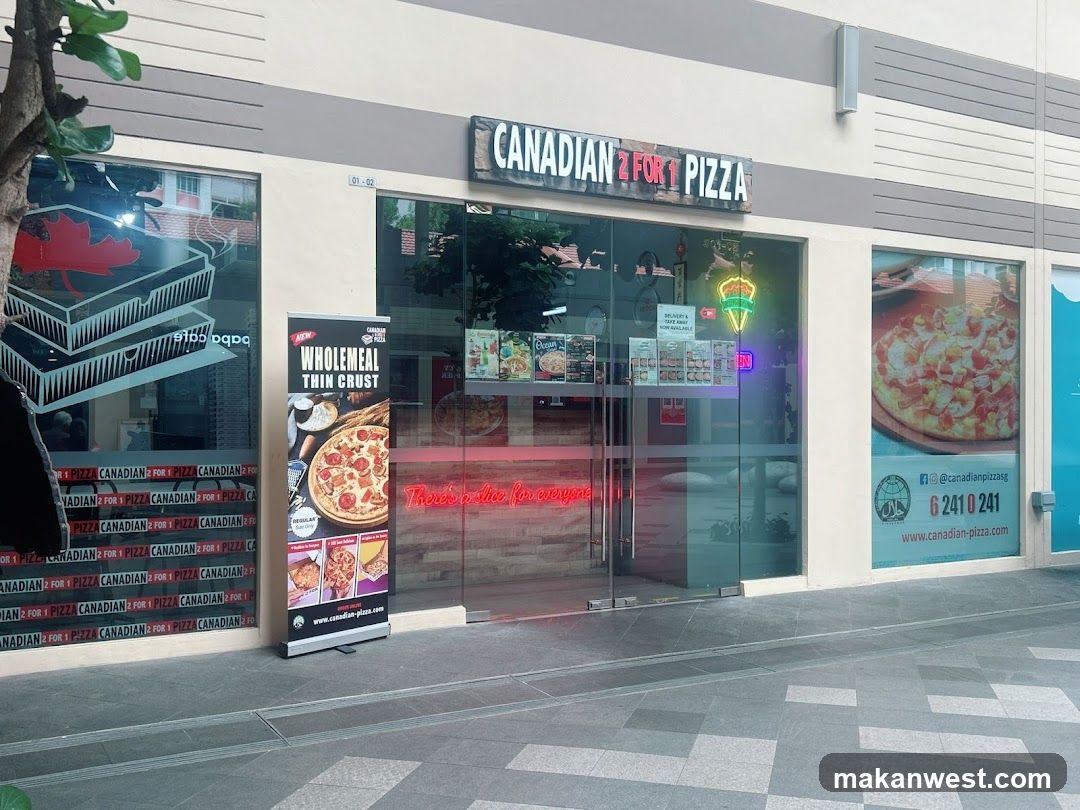 The image shows the exterior of a pizza shop named 'CANADIAN 2 FOR 1 PIZZA'. The storefront features large glass windows and doors with neon signage inside. A vertical poster on the left advertises 'Wholemeal Thin Crust' pizzas, while another window displays promotional images of pizzas. The building facade is light-colored with horizontal stripes.