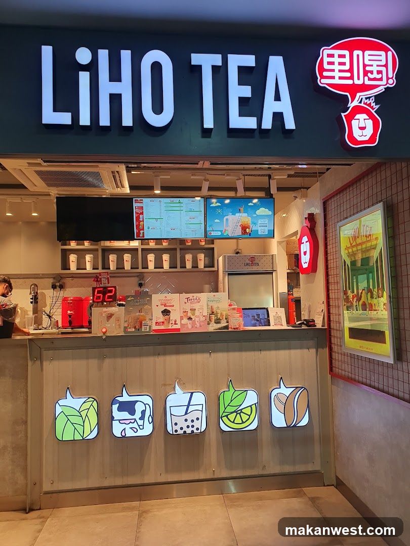 Front view of LiHO TEA shop with illuminated signage, menu boards above counter, and decorative icons on the facade.