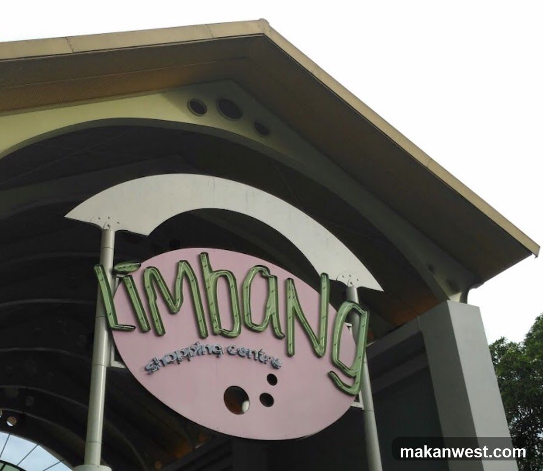 Photo of the exterior entrance facade showing a large circular sign with 'KLIMBANG' in green stylized letters and 'shopping centre' below, mounted under an arched roof structure.