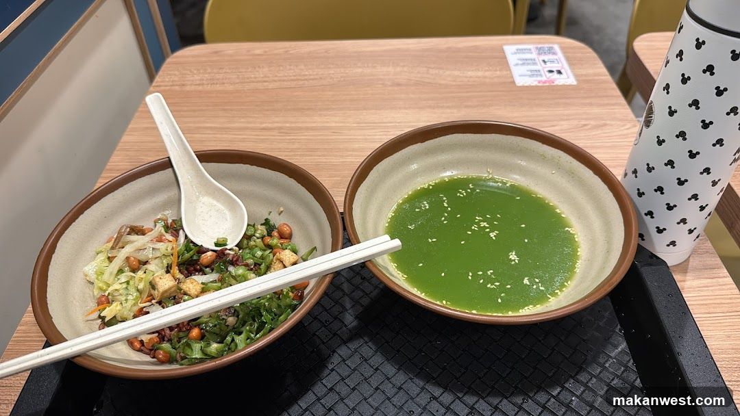 Bowl of salad and green soup with chopsticks