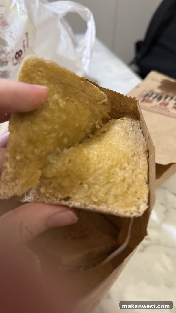 Hand holding bread slices in a paper bag