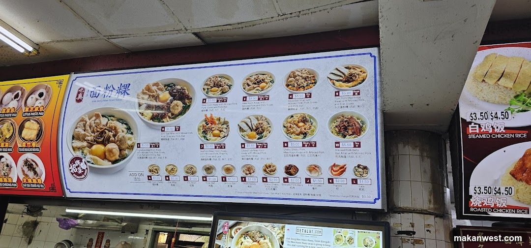 Large illuminated menu board displaying various noodle dishes with prices in HKD, featuring images of bowls and side items like fried eggs and tofu.