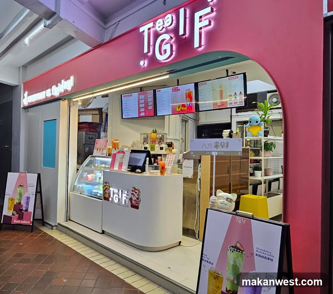 A pink storefront with illuminated 'TEA IF' signage above an arched entrance. Inside, a white counter displays drink samples and menu boards on the wall showing colorful beverages. A yellow stool sits near shelves holding plants and decor. Outside signs advertise green tea drinks.