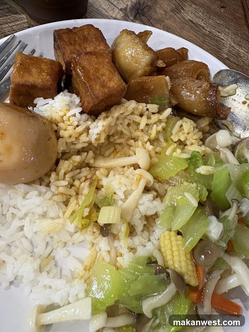 Plate of Chinese-style rice with tofu, braised pork, and stir-fried vegetables