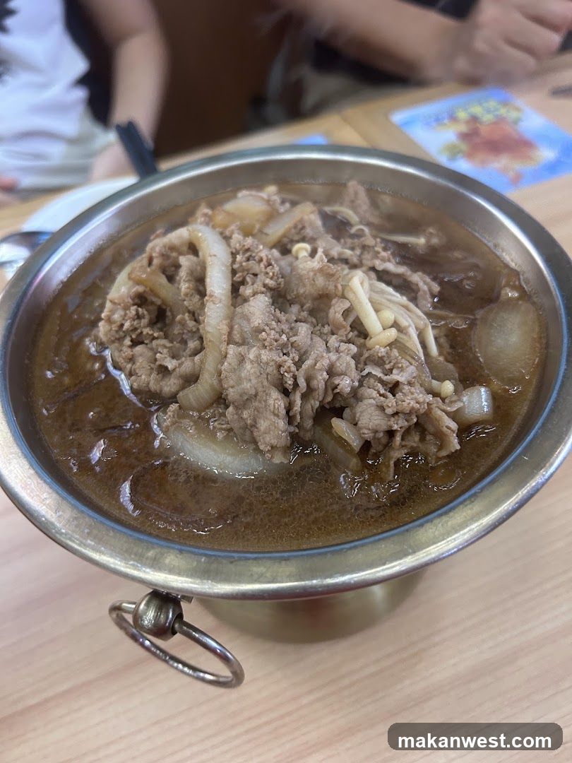 Bowl of Beef Broth with Onions and Enoki Mushrooms
