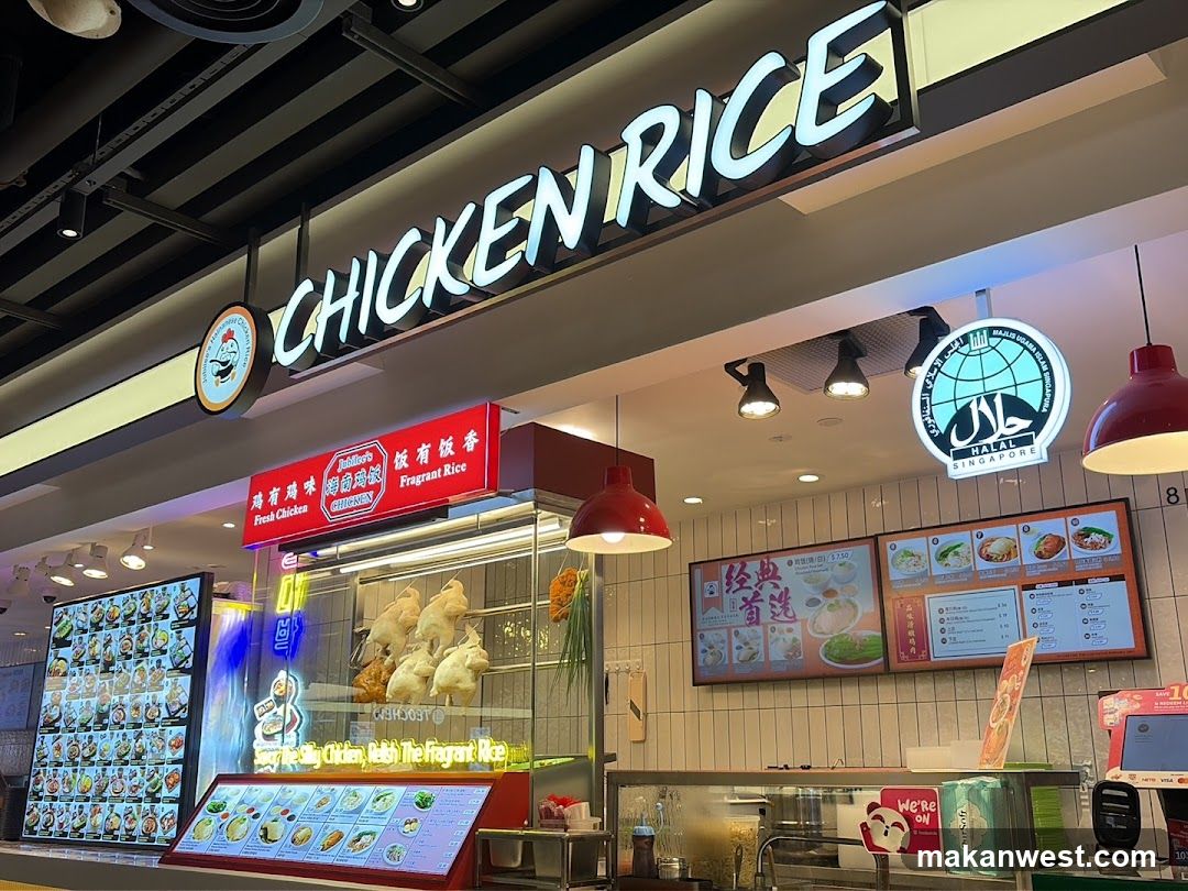 The image shows the storefront of a Chicken Rice shop with illuminated signage reading 'CHICKEN RICE' and a logo featuring a globe and Arabic script. A red signboard displays 'Fragrant Rice'. Inside, roasted chickens are visible in a glass display case. Menu boards on the wall list various rice dishes with prices. Red pendant lights hang above the counter area.