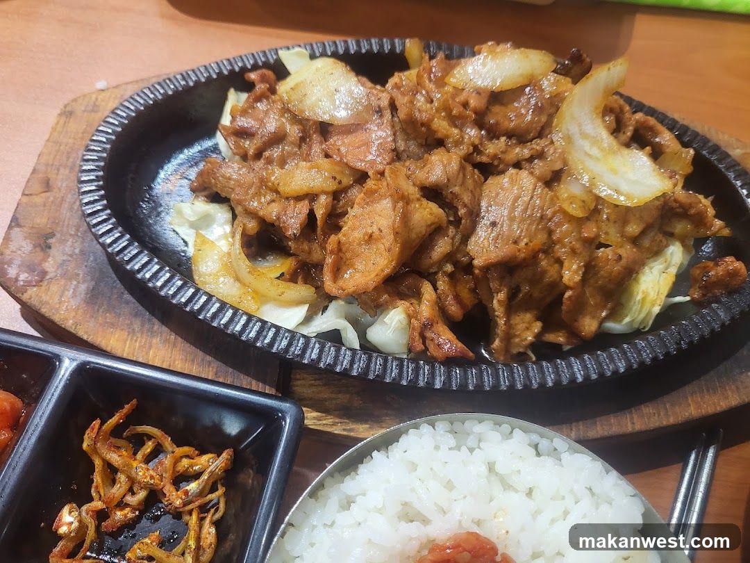 Sizzling Meat Dish with Rice and Side Dishes