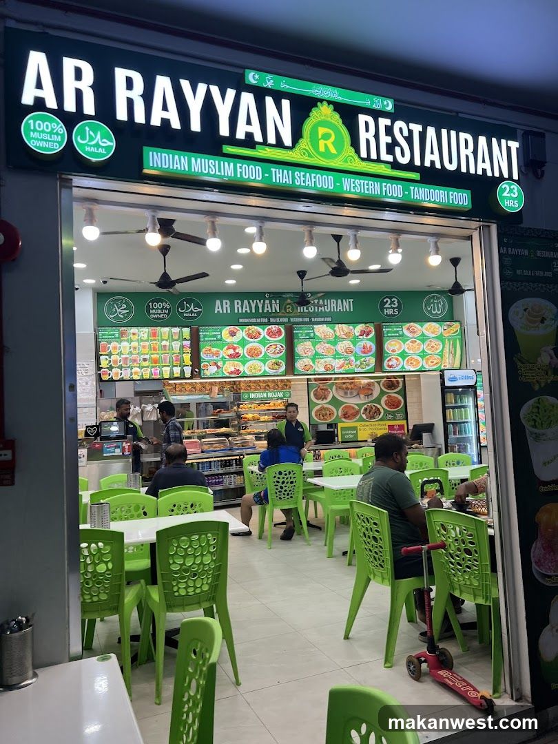 The image shows the storefront of Ar Rayyan Restaurant, featuring a green and white sign with 'AR RAYYAN RESTAURANT' prominently displayed. The entrance is open, revealing an interior with bright lighting, multiple tables, and green plastic chairs. Inside, there are several customers seated at tables, and staff members can be seen behind the counter. A menu board is visible inside, displaying various food items with images and descriptions. The restaurant advertises Indian Muslim food, Thai seafood, Western food, and Tandoori food.