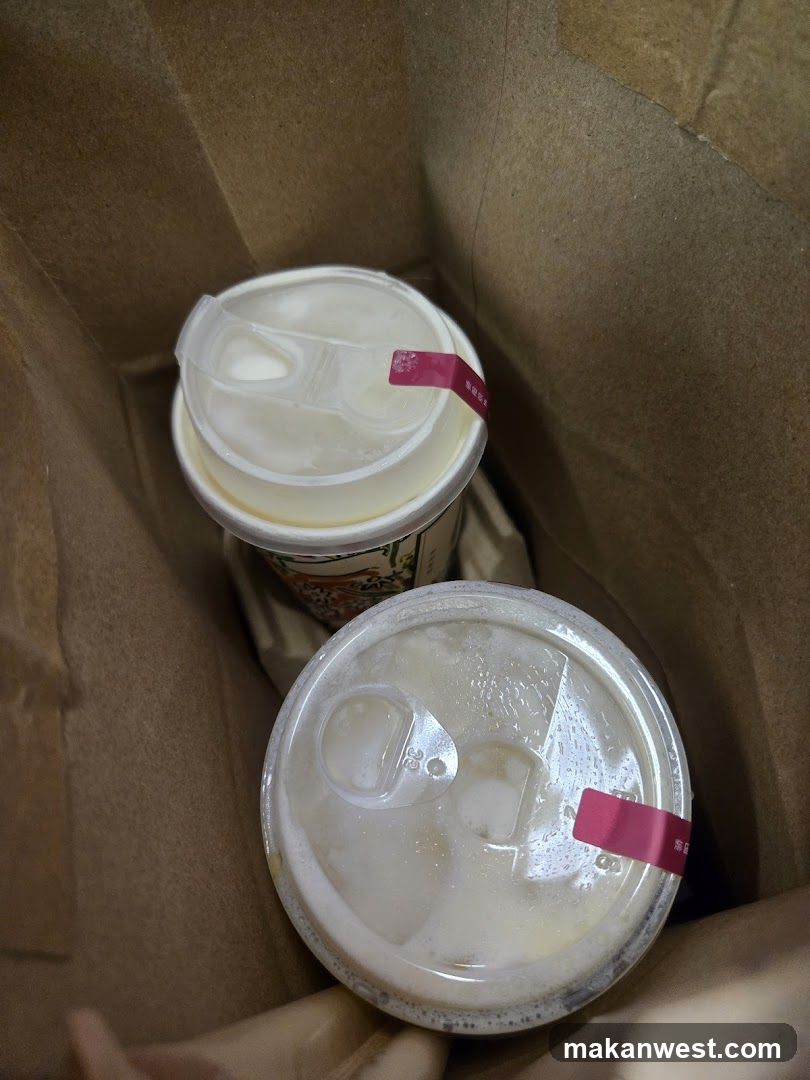 Two iced beverages in a paper bag