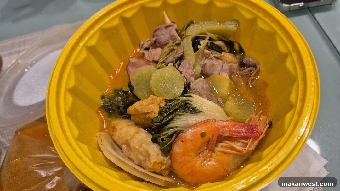 Yellow bowl of soup with shrimp and vegetables