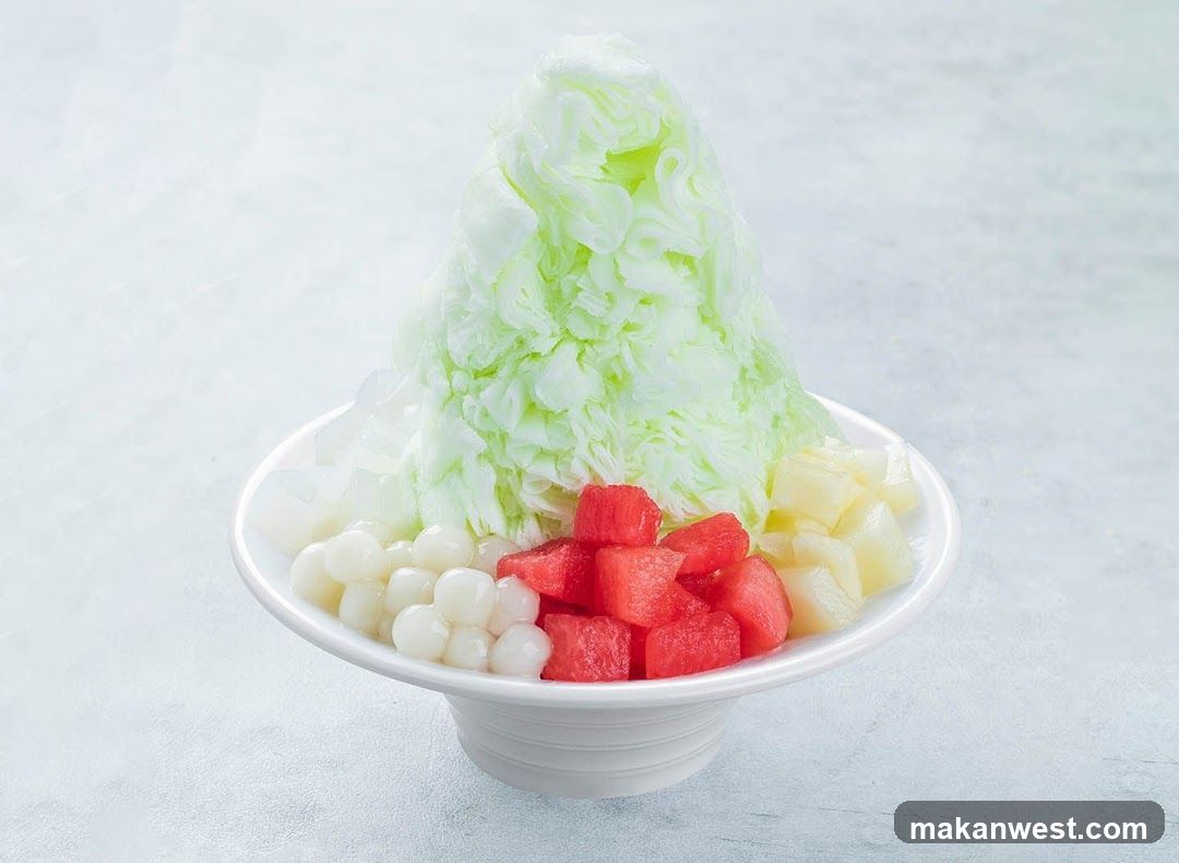 Green shaved ice dessert with fruit toppings