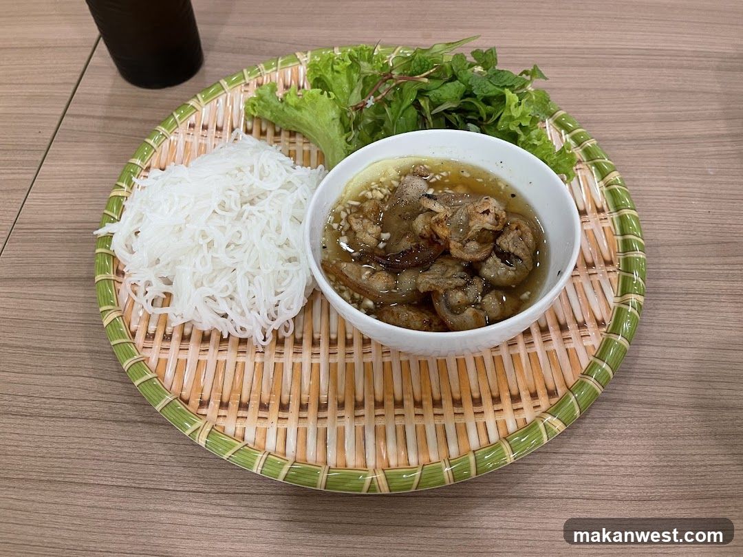 Bowl of meat with rice noodles on a bamboo tray
